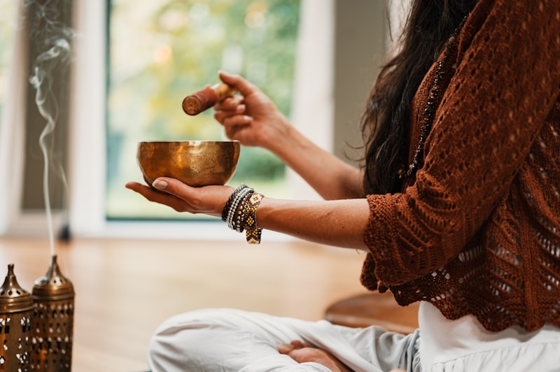 Person sitting in peaceful meditation near a window with morning light